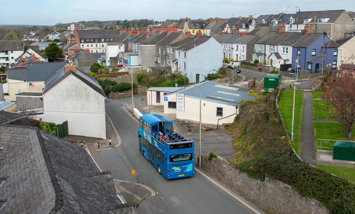 an open-top bus driving down the road